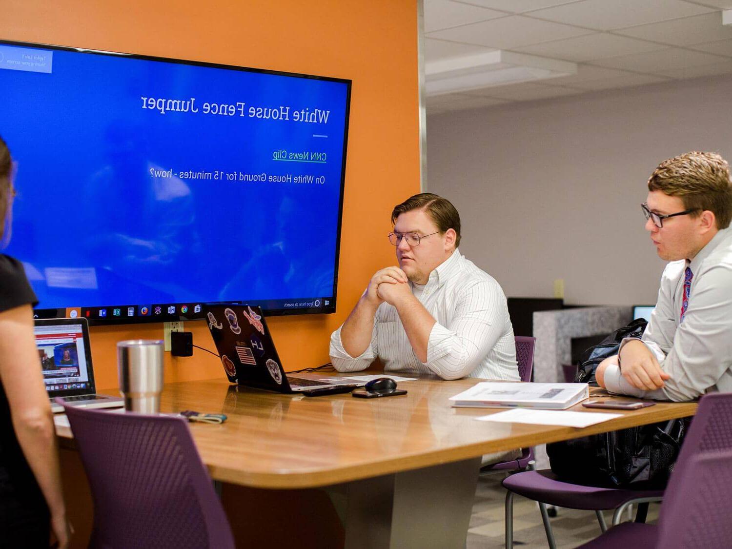 three students use group presentation work space